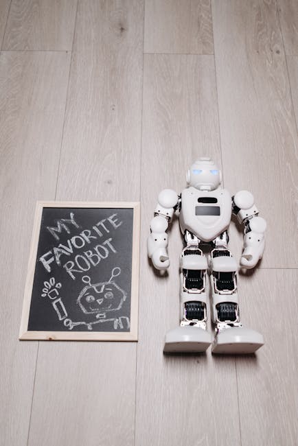 Robot next to chalkboard on a wooden floor, showcasing innovation and art.